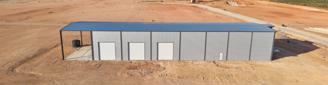 Industrial shop building with wash-bay overhang and multiple overhead doors